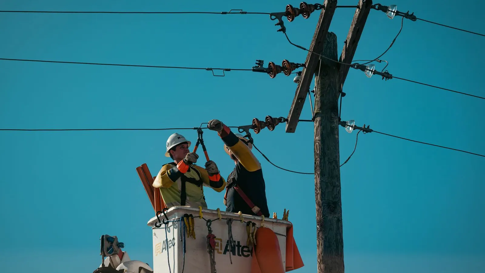 dos-tecnicos-electricos-trabajando-en-un-poste-de-distribucion